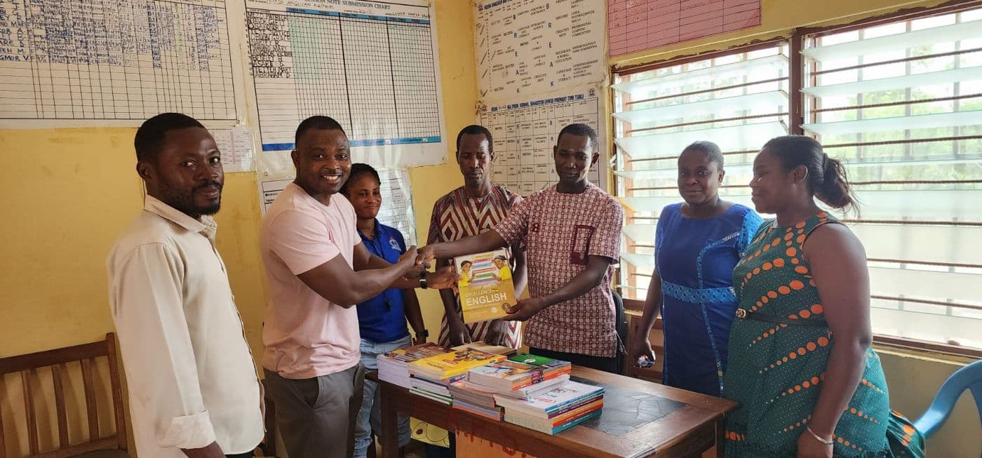 Foundation representatives handing over a set of books to school staff during a supply visit