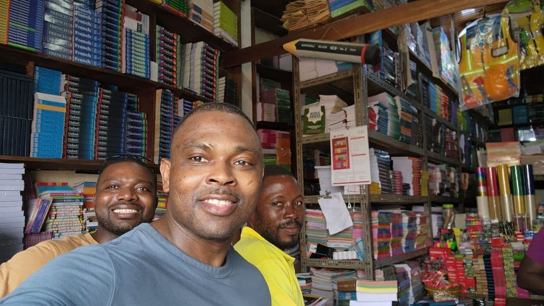 Foundation representatives selecting textbooks and supplies at a stationery shop ahead of a school distribution visit